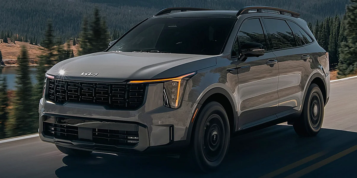 The 2024 Kia Sorrento driving on a highway beside a lake
