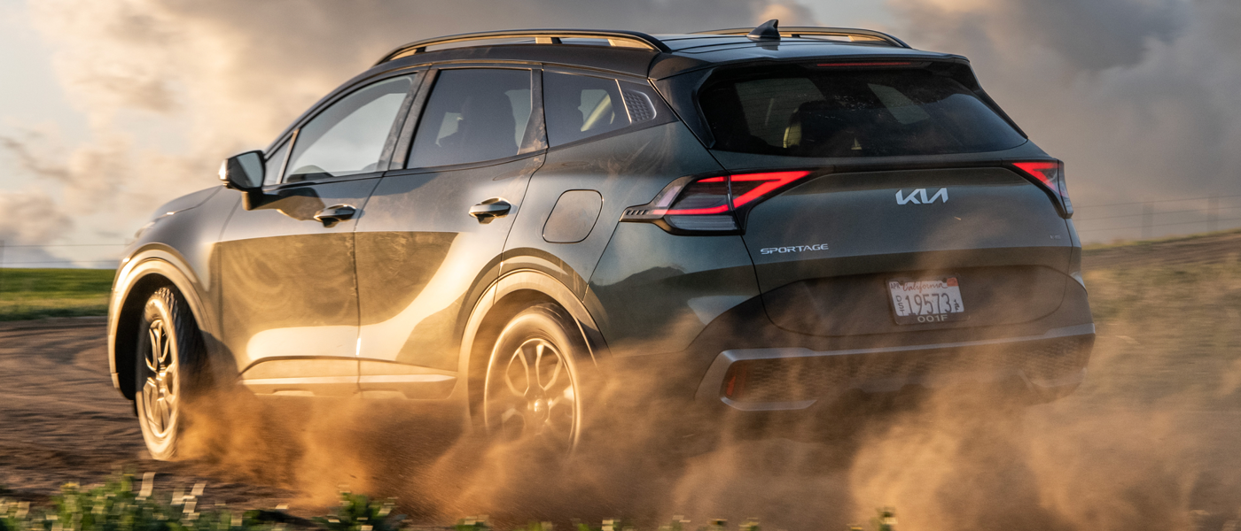 The 2025 Kia Sportage driving through a desert with dust kicking up behind it